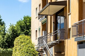 Een meerlaags gebouw met buitenste vluchttrappen, balkons en een bakstenen gevel.