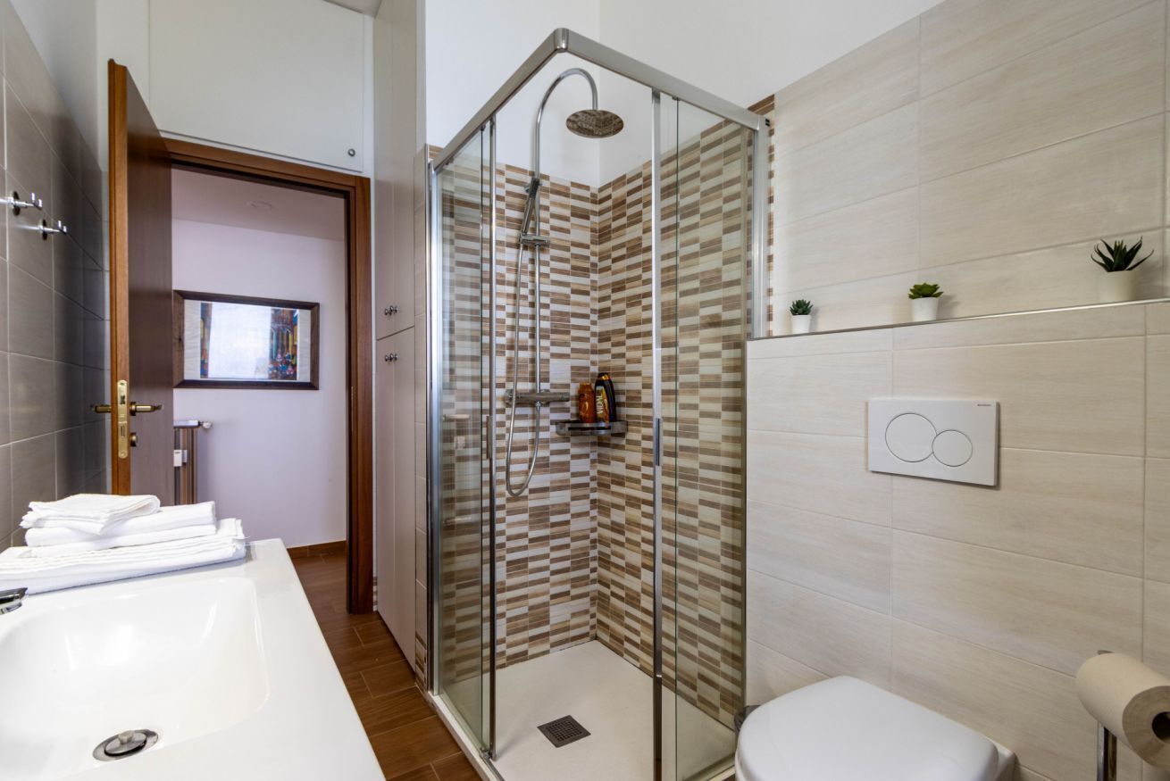 Een douche, een bidet, handdoeken, toiletpapier
