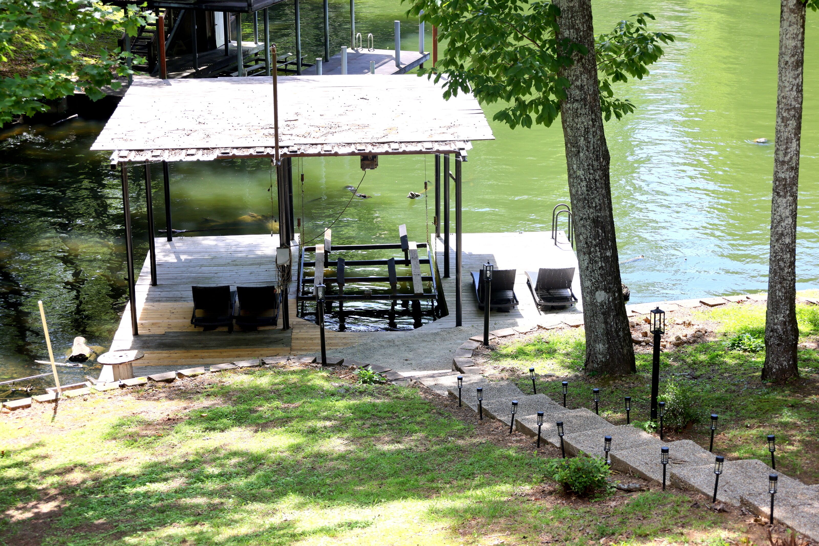 A docked boat, a covered seating area, and a small outdoor table.