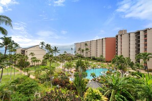 Ein Resort mit Schwimmbad, Palmen und Blick auf den Ozean.