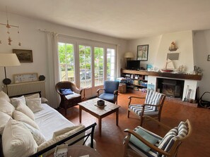 A living room with a sofa, chairs, a coffee table, a fireplace, and a bookshelf. - Family home for 8 people - Beach and village within walking distance (Préfailles)