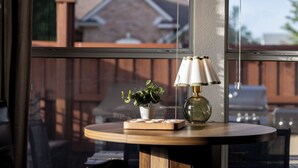 A round wooden table with a lamp and a small plant. - POOL , MINI GOLF & OUTDOOR MOVIE THEATER (McKinney)