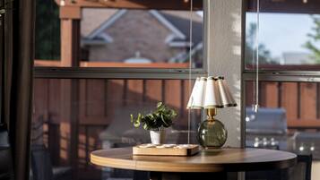 Une table ronde en bois, avec une lampe et une petite plante.