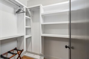 A walk-in closet with open shelving, a coat rack, and a door with a handle. - Y'alliday Inn - Y'all come stay in Nashville's best neighborhood. 3bed/3bath (Nashville)