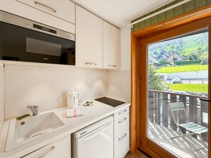 Una cocina moderna con microondas integrado, un lavamanos y una ventana con vistas a un paisaje pintoresco.