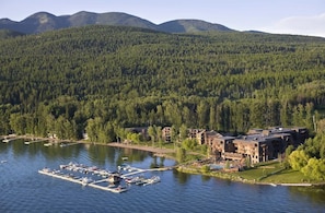 Eine Lodge mit mehreren Gebäuden an einem See, umgeben von dichtem Wald und Bergen.