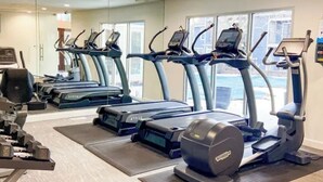 Ein Fitnessstudio mit Laufbändern, Crosstrainern und Kraftgeräten.