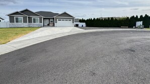 Ein Wohnhaus mit Garage, Auffahrt und gepflegtem Rasen.