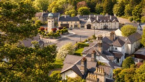 A historic building with a central tower, surrounded by a small village with traditional architecture. - Powerscourt Arms Hotel (Enniskerry)