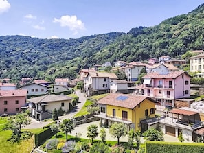 A residential area with houses, a central pathway, and a hilly backdrop. - Casa Giamba by Interhome (Plesio)