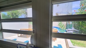 Opaste, jossa lukee ”Beach House”, ja josta näkyy ulkona oleva oleskelualue ja viheralue.
