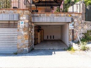 A stone building with a metal gate and a sign indicating a parking area. - Apartment Daisy by Interhome (Imperia)