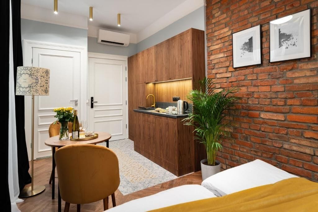 Habitación de hotel compacta con kitchenette, zona de comedor y cama.