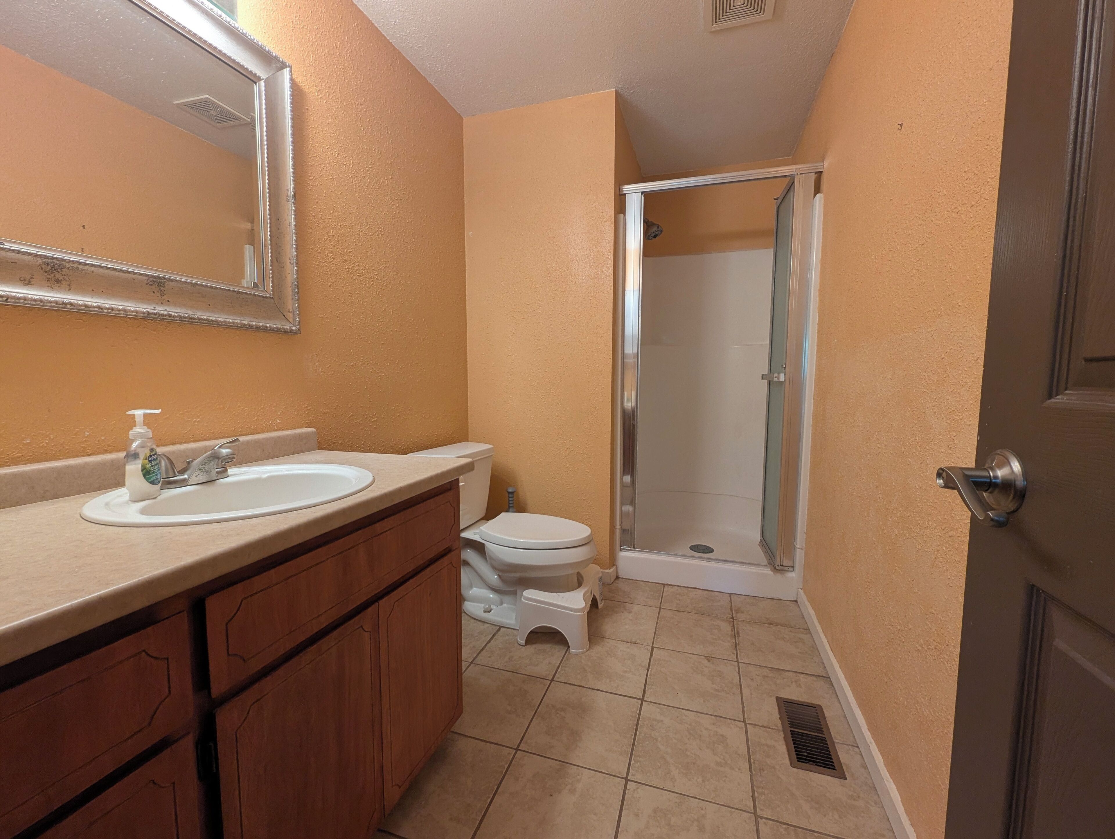 A bathroom with a sink, toilet, and shower.