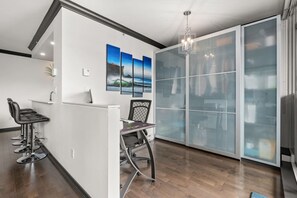Ein modernes Interieur mit Barbereich, Essbereich und einer großen Schiebeglasdoor, die auf einen Balkon führt.