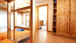 A room with a bunk bed, wooden flooring, and a wardrobe. - Chasa Aglia, (Ftan) by Interhome (Ftan)