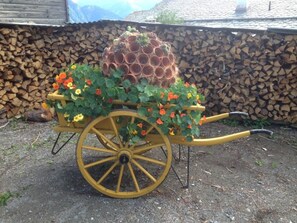 A wheelbarrow with a flower arrangement and a stack of pots.