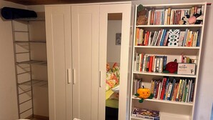 A bedroom with a bed, a wardrobe, a bookshelf, and a ladder. - Bijouswiss - The Yellow House****, (Oberterzen), by Interhome (Oberterzen)