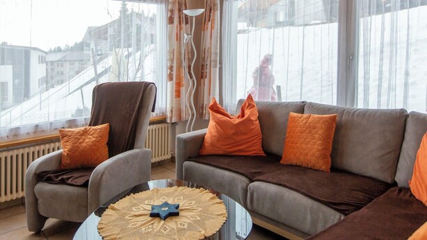 A living room with a sofa, armchairs, and a coffee table.