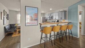 Un appartement moderne comprenant une cuisine, un coin repas et un salon.