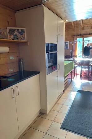 A kitchen with white cabinets, a black countertop, and a visible water bottle.
