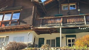 Ein zweistöckiges Holzhaus mit Balkon, Fenstern und einer Tür.