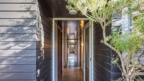 A narrow hallway with wooden walls and a door at the end. - East Lane (Bega Valley)