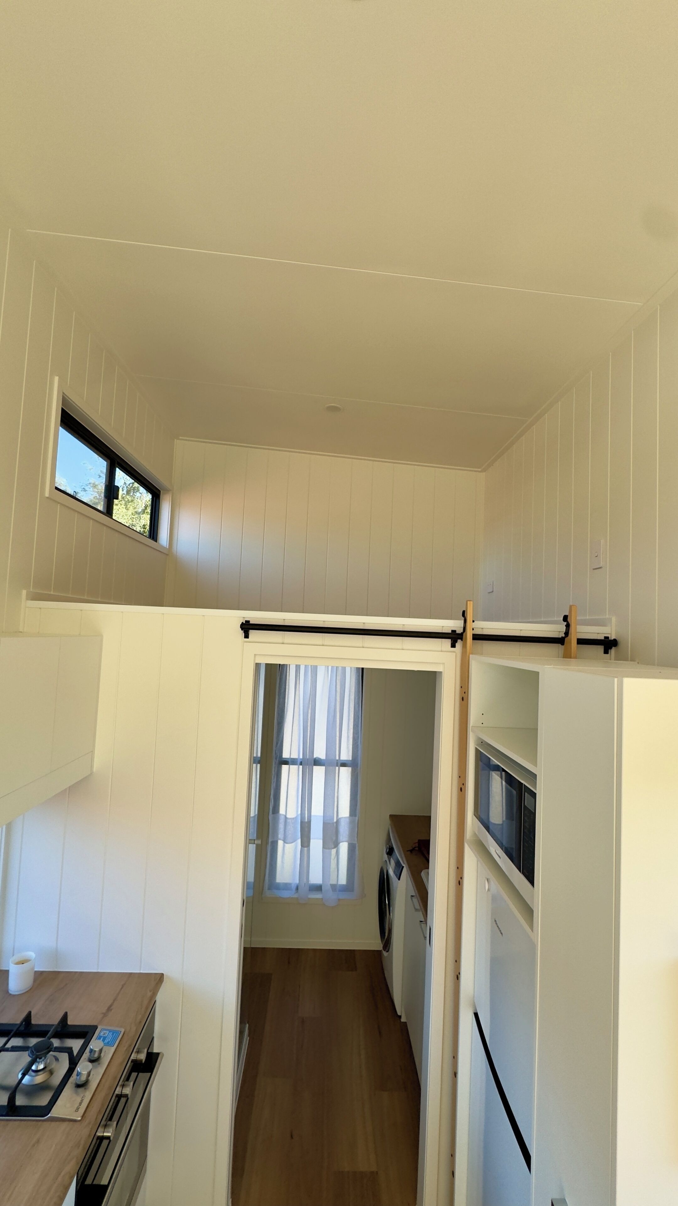 A compact kitchen with a gas stove, a microwave, and a refrigerator.