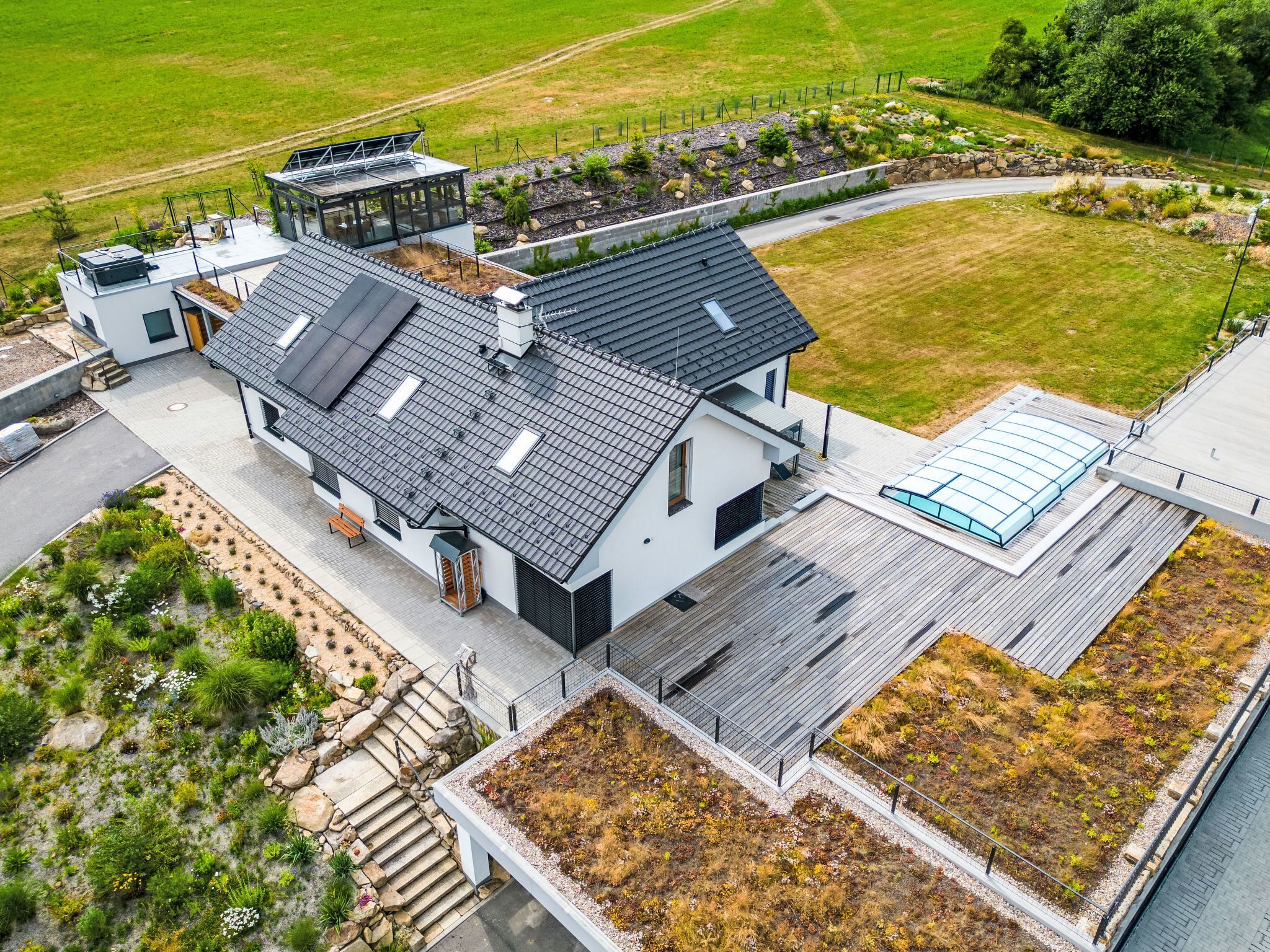 Une maison moderne avec un toit plat, de grandes fenêtres et un jardin.
