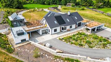Une maison moderne avec un toit en pente, une véranda et une allée.