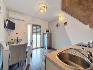 A modern kitchen with a stainless steel sink, a built-in microwave, and a refrigerator. - Apartment Vigi by Interhome (Pag/Povljana)