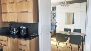 A modern kitchen with wooden cabinets and a dining area with a table and chairs. - Dzielna by Interhome (Warsaw)