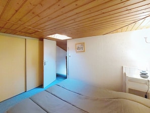 A room with a wooden ceiling, a tatami mat floor, a wardrobe, a small table with a lamp, and a framed picture on the wall. - Hameau de Talaris by Interhome (Les Mathes)