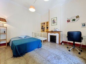 Une pièce comprenant un lit, un berceau, une bibliothèque, une cheminée et un bureau avec une chaise.