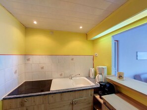 A kitchen with a sink, countertop, cabinets, and a coffee maker. - Lydia Playa by Interhome (Le Barcarès)