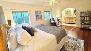 A bedroom with a bed, a ceiling fan, a dresser, a chair, and a bookshelf. - Lux Lodge Downtown w/ AC, Bonus Cottage, Courtyard (McCall)