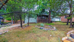 A residential area with a house, a wooden deck, and a stone pathway. - Lazy D Cabin: Inspired by a West Texas ranch. Built for mountain memories. (Ruidoso)