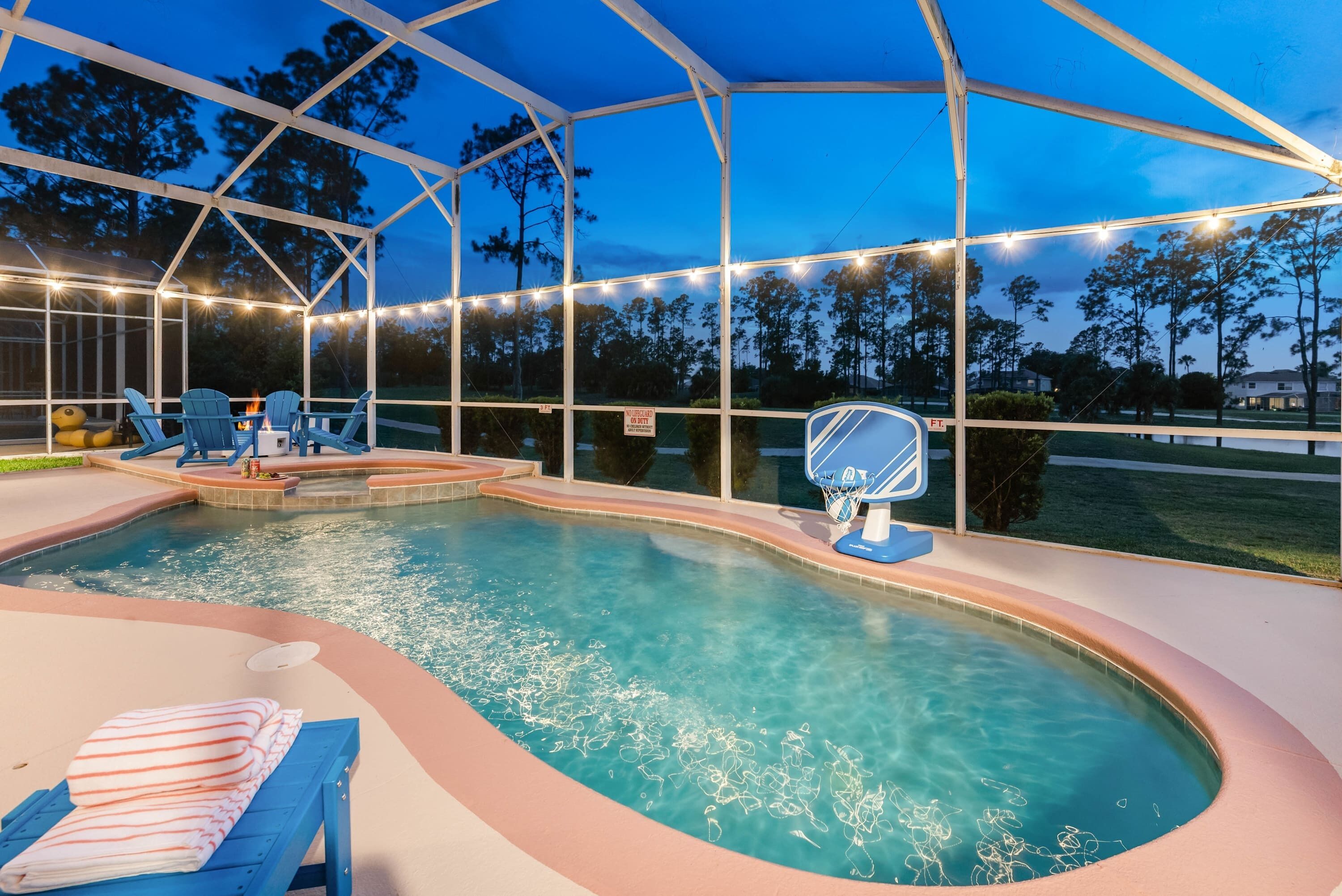 A swimming pool with a sunken hot tub, lounge chairs, and a covered patio area.