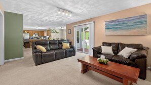 Ein Wohnzimmer mit einer Couch, einem Couchtisch und einem Gemälde an der Wand.