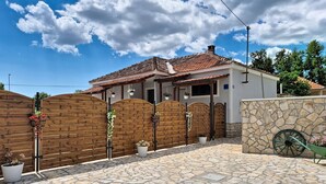 A house with a stone patio, wooden gate, and a wheelbarrow. - Vacation home Denis by Interhome (Benkovac)