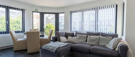 A modern living room with a sofa, armchair, and coffee table.