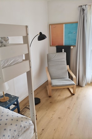 A room with a bunk bed, a desk with a lamp, a chair, a radiator, and a painting on the wall. - Solaria 31 Ferienhaus, Dusche oder Bad, WC 5 1/2- Ferienhaus by Interhome (Davos)