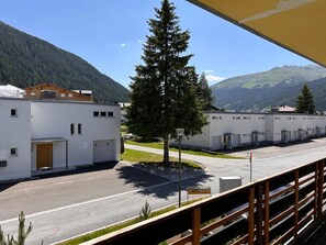 A modern building with a parking area, a street lamp, and a sign reading 'METTLER PRADER.' - Solaria 31 Ferienhaus, Dusche oder Bad, WC 5 1/2- Ferienhaus by Interhome (Davos)
