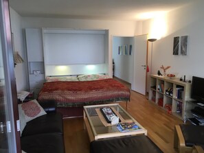 A compact living space with a bed, a glass coffee table, a sofa, a TV, and a bookshelf. - Belette 31 Appartement/Fewo, Dusche oder Bad, WC 2½-Zimmerwohnung by Interhome (Davos)
