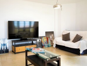 A modern living room with a flat-screen TV, a glass coffee table, a sofa, and artwork on the walls. - La samba beachfront by Interhome (Rincón de la Victoria)