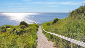 A coastal path leading to the sea with a wooden railing and greenery. - "Skakke" - 350m to the fjord by Interhome (Vestervig)