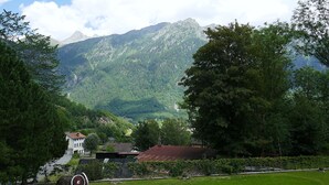 Paisaje montañoso con una casa en primer plano.