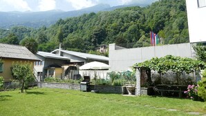 Zona residencial con casas, una zona de barbacoa y un muro de piedra.