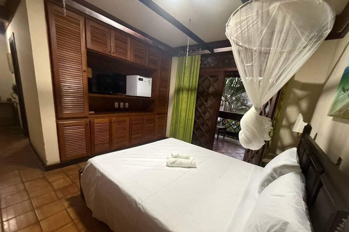 Ein Schlafzimmer mit einem Bett, einem Fernseher und einem Kleiderschrank.