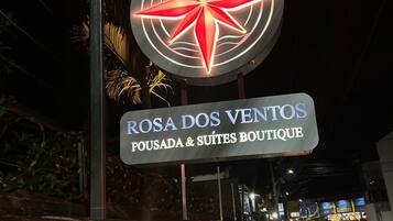 Placa do hotel Rosa dos Ventos Boutique com um design de estrela iluminada em destaque.